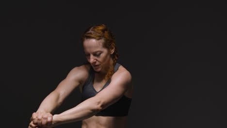 Foto-De-Estudio-De-Una-Mujer-Madura-Vistiendo-Ropa-De-Gimnasio-Haciendo-Ejercicios-De-Estiramiento